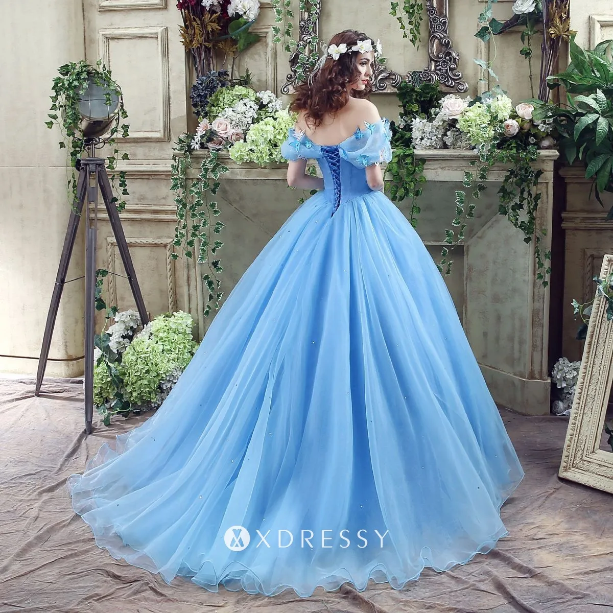 A stunning butterfly gown on a high-end mannequin with highly quality  details and real photo with shiny stone and bright accessories and the  colors are gold purples and violet and dark blue