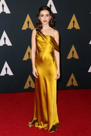 Lily Collins shiny gold satin one shoulder red carpet evening prom dress
