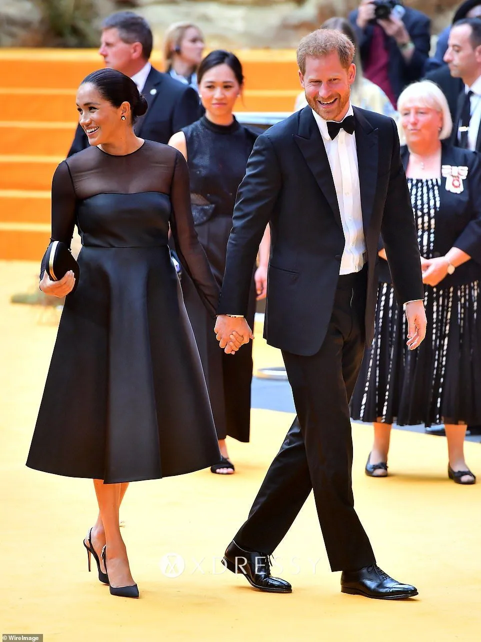 Meghan Markle little black satin celebrity dress with sheer long sleeves at the European premiere of The Lion King Meghan Markle little black satin celebrity dress with sheer long sleeves at the European premiere of The Lion King