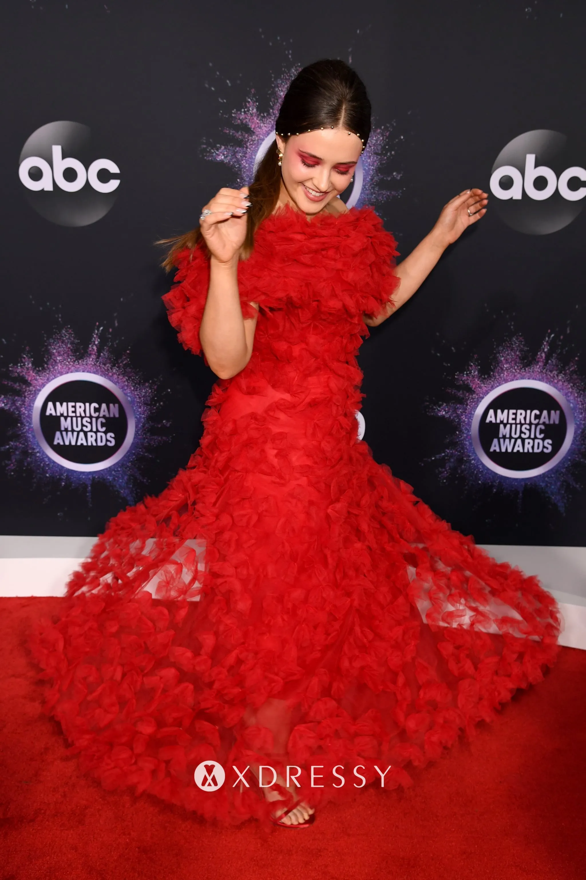 Katherine Langford in a red tulle off the shoulder fashion A line prom gown at the 2019 American Music Awards red carpet Katherine Langford in a red tulle off the shoulder fashion A line prom gown at the 2019 American Music Awards red carpet
