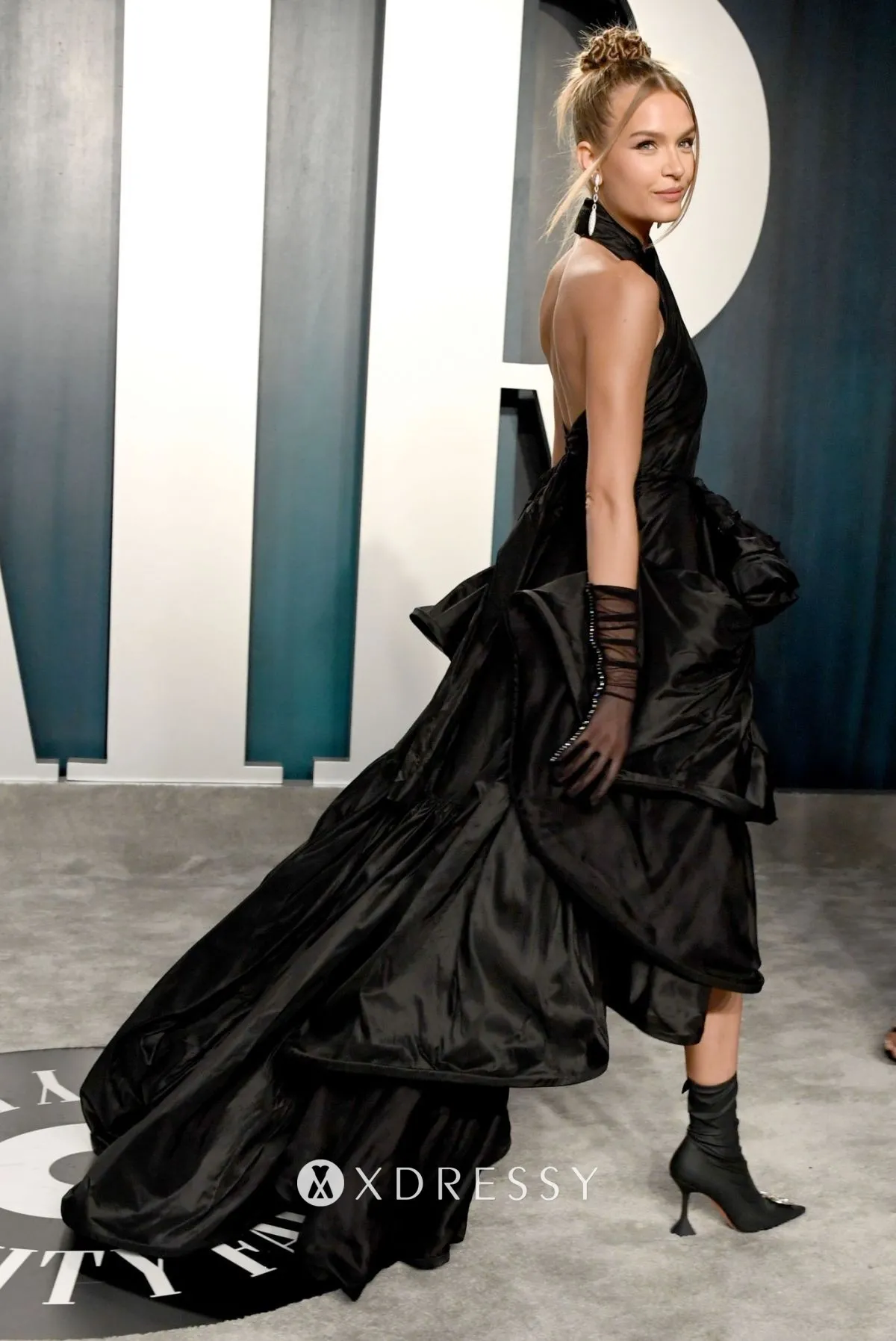 Josephine Skriver looked flirty in a draped black high low cut out prom dress with a criss cross halter neck Josephine Skriver looked flirty in a draped black high low cut out prom dress with a criss cross halter neck