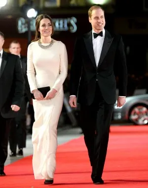Kate Middleton in an ivory floor length evening dress with long sleeves arrives at Claridges to support Prince William