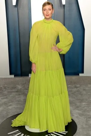 Maria Sharapova attends Vanity Fair Oscar Party 2020 featuring a see through lemon green chiffon evening dress