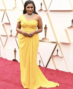 Mindy Kaling was bright and elegant in a yellow one shoulder evening prom formal gown at the 2020 Oscars red carpet